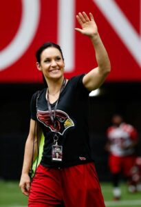 a happy women's Football coach waving