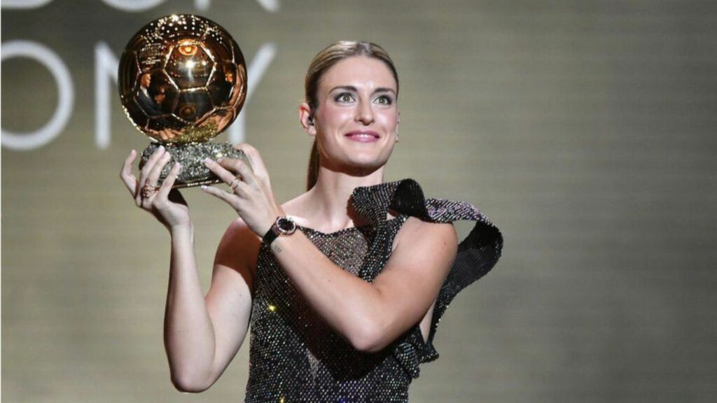 a lady who is holding a trophy from women's football